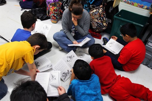Photo by Jennifer Whitney  A reading assistant reads on the classroom floor with a small group of fourth graders at Wanke Elementary School in San Antonio on March 9, 2012. 